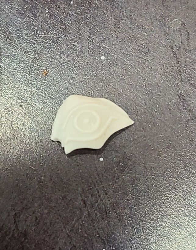 Jagged piece with what looks to be an etched eye on the surgace.